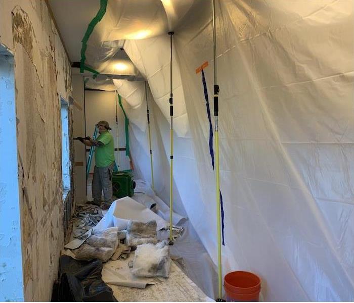 SERVPRO working in a containment area on mold damage
